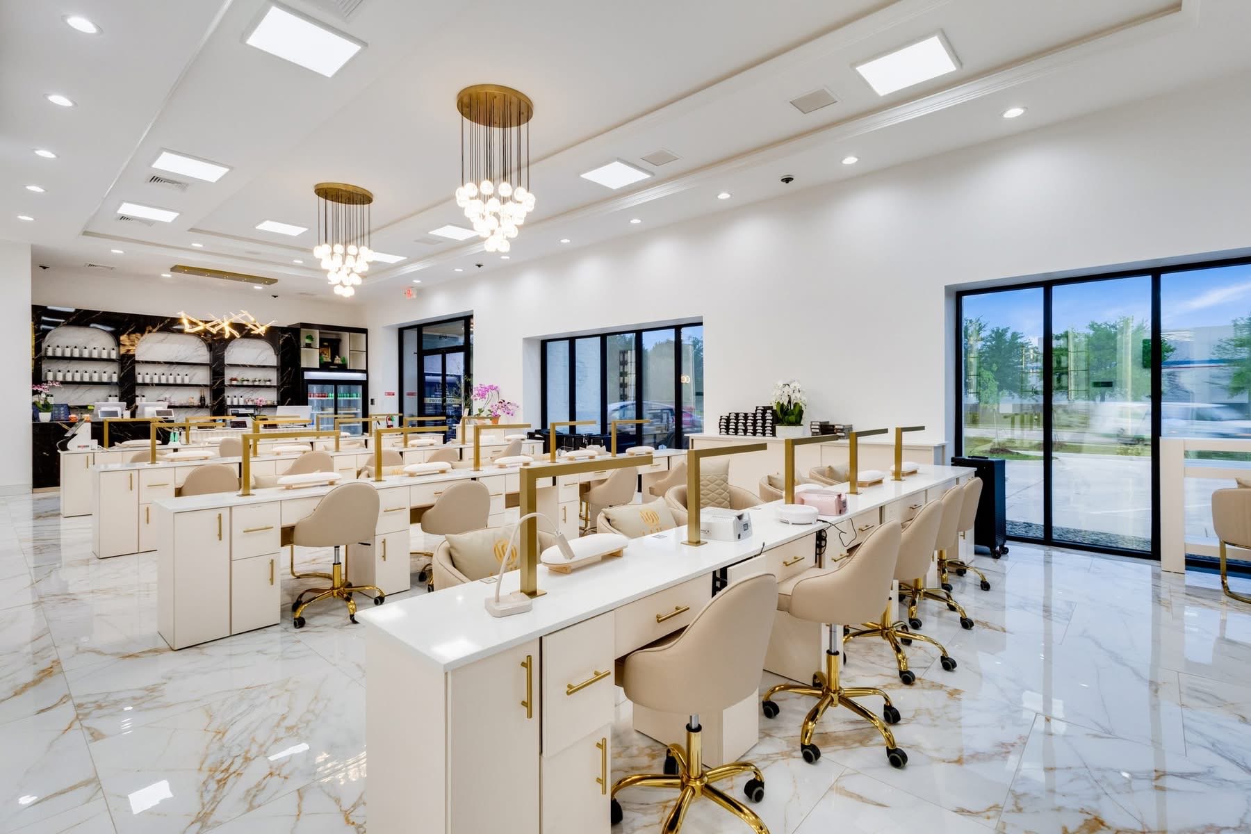 UNIQ Nail Lounge main floor with twin gold globe chandeliers and rows of manicure stations