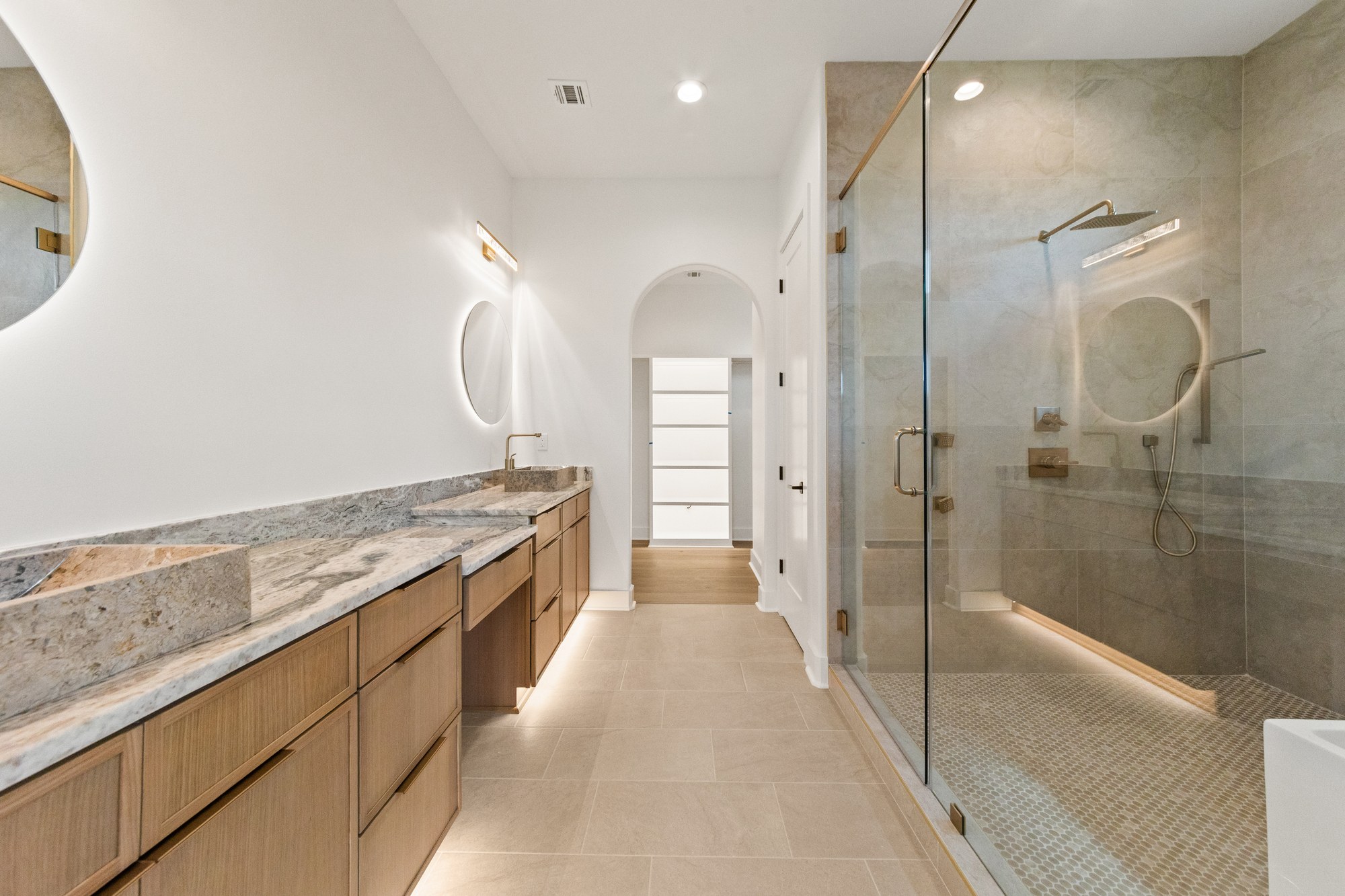 Double vanity, illuminated mirrors, and a glass shower at 221 Gunter Grass