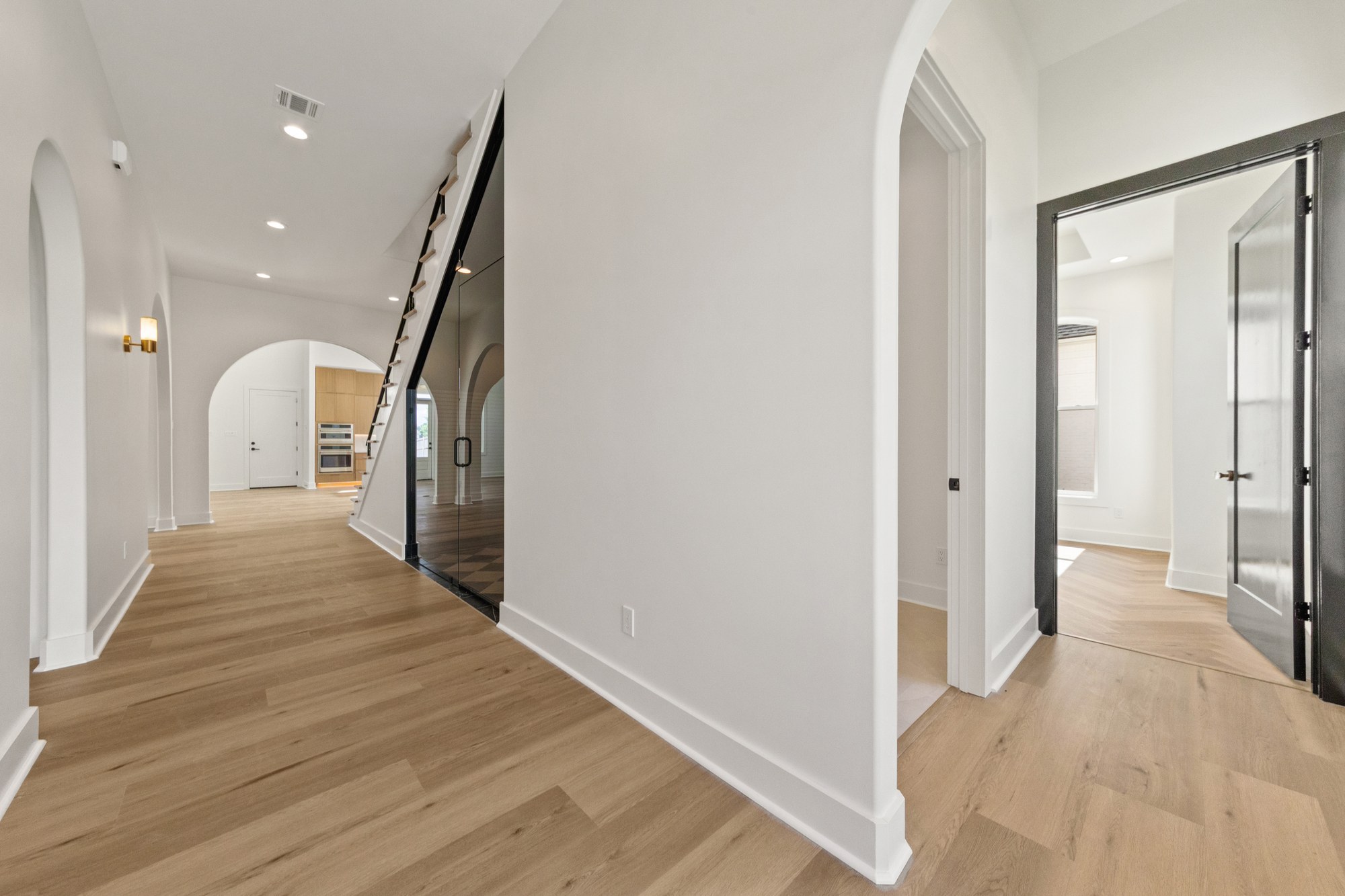 Arched openings and warm wood flooring at 221 Gunter Grass